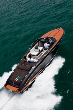 a motor boat with two people on it in the middle of the water, from above