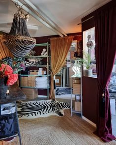 a living room filled with furniture and a chandelier hanging over the top of it