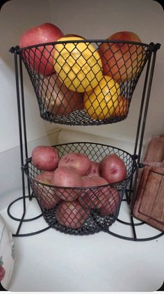 two metal baskets filled with fruit on top of a counter