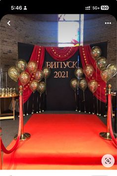 a red carpet with gold balloons on it and a sign that says battyck