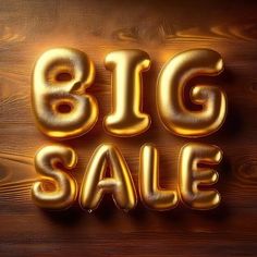 the words big sale are made out of gold foil balloons on a wooden background with wood grain