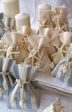 some white candles and blue striped bags on a table