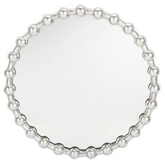 a round mirror with silver balls on the rim and an oval frame in the middle