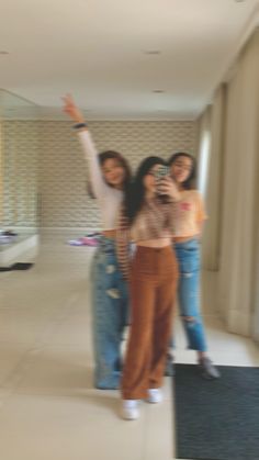 three young women are taking a selfie in an empty room