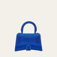 Balenciaga "Hourglass" top-handle bag in allover strass suede and calf leather Rolled top handle Removable, adjustable shoulder strap Can be worn as a top handle or shoulder bag  Flap top with hanging "B" hardware; snap closure Approx. 7.5"H x 5.1"W x 3.1"D Made in Italy Luxury Handheld Shoulder Bag For Night Out, Luxury Handheld Shoulder Bag With Single Handle, Luxury Top Handle Bag With Single Handle, Luxury Bags With Detachable Handle For Night Out, Luxury Bag With Detachable Handle For Night Out, Luxury Single Handle Shoulder Bag, Luxury Top Handle Evening Bag For Night Out, Luxury Handheld Bag With Single Handle, Evening Shoulder Bag With Single Top Handle