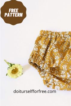 a yellow flower sitting on top of a white table next to a pair of shorts