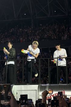 three men on stage with one holding a frisbee