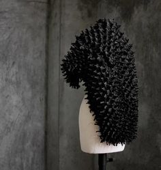 there is a hair brush on top of a mannequin's head in front of a wall