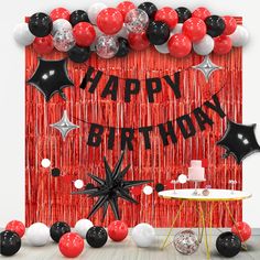 a red and black birthday party with balloons, streamers, cake table and decorations