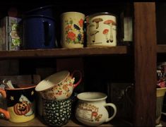 there are many mugs on the shelf together