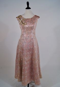 "Wowzers! This vintage 1950s Ann's vogue Shoppe gown is a stunner! It is a full length pink and silver brocade gown with sequin and beaded appliqué on the shoulder. It zips up the back (the original zipper has been replaced) and has a bow at the lower back. It is fully lined in pink acetate and is in excellent condition but does have areas of discoloration in skirt folds and under the arms. Size: M Bust: 34\" Waist: 29\" Hips:Open Length: 52\"" Evening Dress With Fitted Brocade Bodice, Evening Dress With Fitted Bodice In Brocade, Fitted Brocade Evening Dress, Brocade Evening Dress With Fitted Bodice, Pink Evening Gown For Festive Occasions, Party Embellished Brocade Dress, Embellished Brocade Party Dress, Brocade Embellished Party Dress, Party Brocade Embellished Dresses