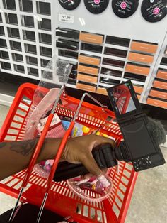 a person sitting in a shopping cart holding a cell phone