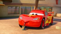 the character from pixar animation studios in front of a building with cars painted on it