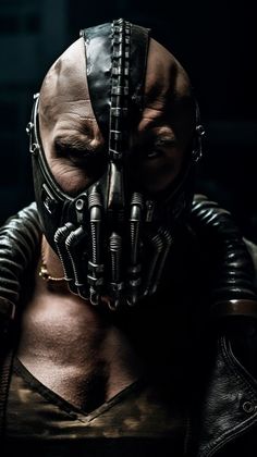 a man wearing a leather mask with metal spikes on his face and chest, standing in front of a dark background