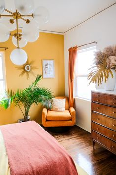 a bedroom with yellow walls and wooden floors