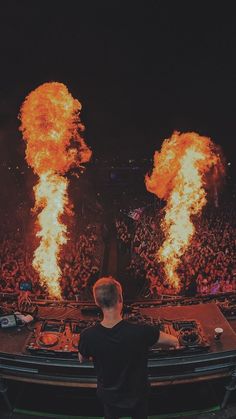 a man standing in front of a dj set on fire