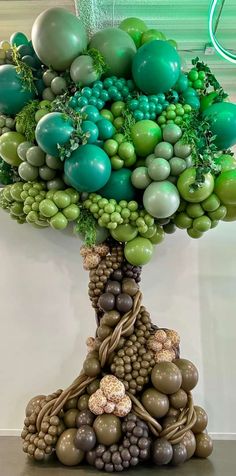 a tree made out of grapes and other items in the shape of a pyramid with balloons attached to it