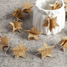 some brown stars are laying on the ground next to a white cup and string lights