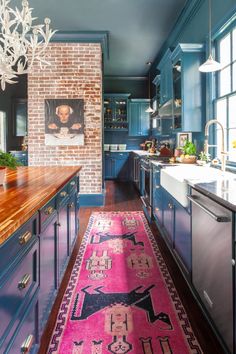 a kitchen with blue cabinets and an area rug