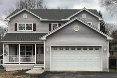 a two story house with white trim and red shutters on the front door is shown