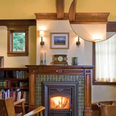 a living room with a fire place and bookshelves on the wall next to it