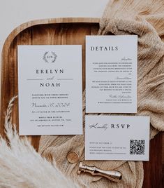 the wedding stationery is laid out on a wooden tray