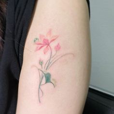 a woman's arm with a flower tattoo on the left side of her arm