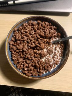 a bowl of cereal is sitting on a desk next to a computer keyboard and mouse