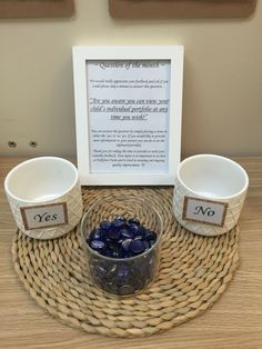 two bowls with rocks in them sitting on a wicker table next to a sign