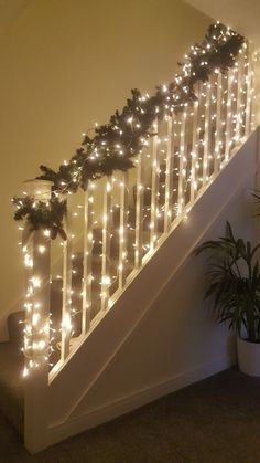 christmas garland on the bannister railing with lights and greenery at the bottom