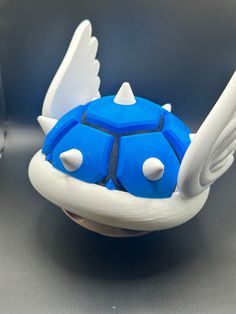 a blue and white object with wings on it's back end sitting on a table