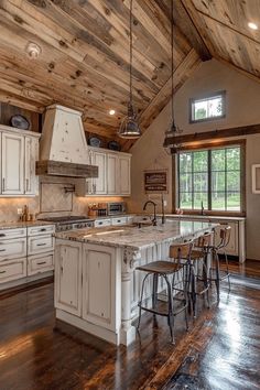 a large kitchen with white cabinets and wooden ceilinging, along with an island in the middle