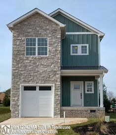 a two story brick house with white garage doors