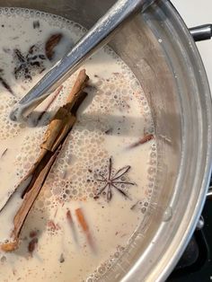 a pot filled with liquid and cinnamon sticks