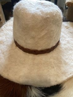 Handmade felt white sheep wool cowboy style hat with brown braided leather band, and red poly-satin lining. 3.5-4 inch brim. Unisex and hat size is 23 inches. Hat is signed and dated inside. Made with 100% wool and is sourced domestic and exotic. White Western Felt Hat For The Beach, Brown Felt Hat Band For Country Events, White Wide Brim Felt Hat For Rodeo, White Country Style Felt Hat For The Beach, Cream Country Style Hat Bands For Western-themed Events, Country Style White Felt Hat For The Beach, White Country Style Felt Hat For Beach, Country Style Cream Hat Bands For Western-themed Events, Country Style White Felt Hat For Beach