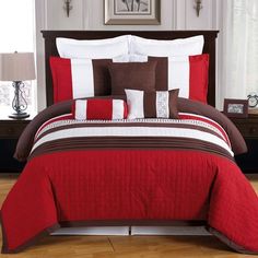 a bed with red and brown comforters in a room