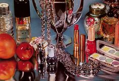 there are many items on the table including lipstick, perfume bottles, and other things