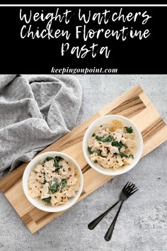 two bowls filled with pasta on top of a wooden cutting board