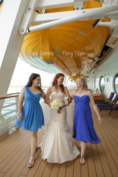 three brides are walking on the deck of a cruise ship, dressed in blue and white