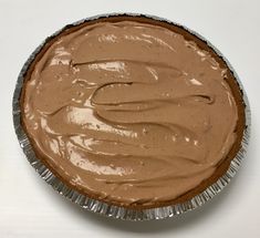 there is a pie with chocolate frosting in the pie pan on the counter top