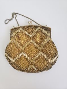 "Vintage gold beaded evening bag with diamond geometric design and kiss closure. There are two rhinestones accenting the closure. Hand made in Hong Kong for Du Val. The 14\" metal strap fits comfortable over the wrist or forearm. The lining is gold tone silky material.  The purse measures approximately 6 1/2\"by 6 3/4\" and the opening extends to 5\".  In very good condition with no missing beads and clean lining. Previously owned. There are subtle signs of age/use on the metal opening of the purse. Please see the photos as they are part of the description. Please do browse our other items as we do combine shipping for savings." Elegant Evening Clutch With Gold Beads, Elegant Gold Beaded Evening Clutch, Gold Beaded Pouch Shoulder Bag, Rectangular Evening Bags With Gold Beads, Gold Beaded Pouch Bag, Elegant Gold Clutch With Gold Beads, Gold Embellished Evening Shoulder Bag, Elegant Gold Beaded Clutch, Gold Vintage Shoulder Bag