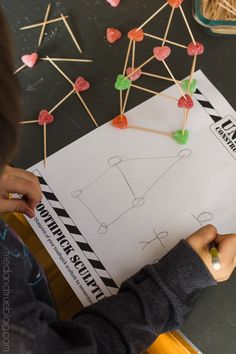 a young boy is working on some crafting with lollipops and sticks