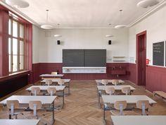 an empty classroom with desks and chalkboard