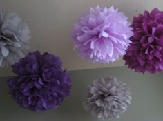 purple and white paper flowers hanging from the ceiling