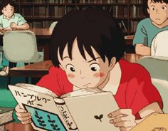 a young boy reading a book in front of other children sitting at desks with bookshelves