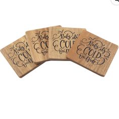 four wooden coasters with black lettering on them