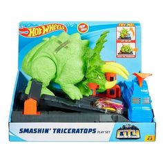 a toy train set with a green dinosaur riding on it's tracks in a box