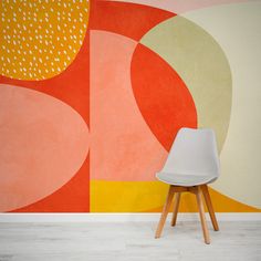 a white chair sitting in front of a colorful wall