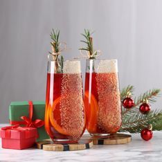 two wine glasses filled with red liquid and sprinkles