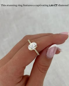 a woman's hand holding an engagement ring with a diamond on the middle finger